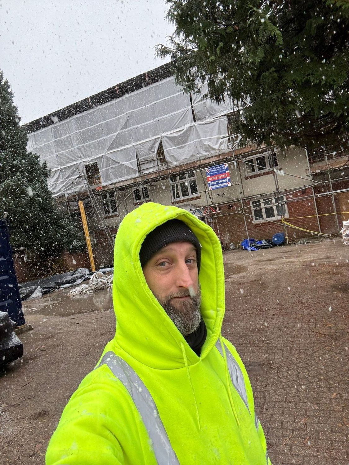 Kris on site with the house under scaffold